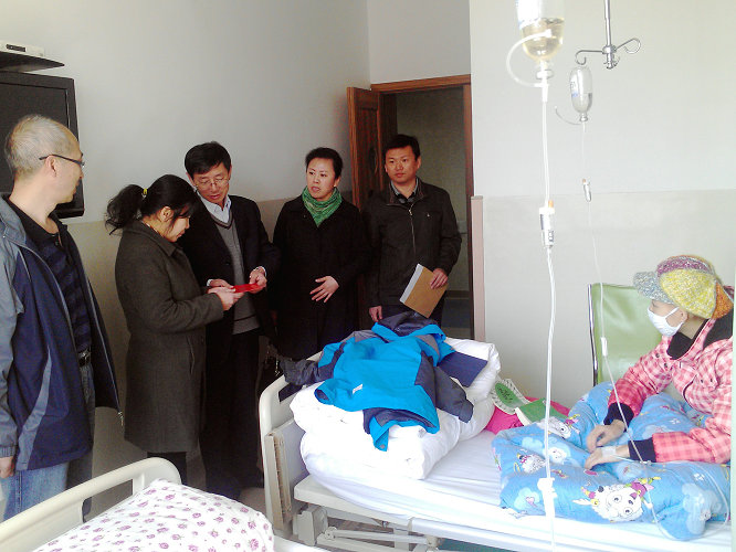 4.2014年4月16日,市慈善总会副秘书长赵娣(右二)等一行,来到独山子区石化医院我白血病患者杨晓帝送去医疗救助金。.jpg