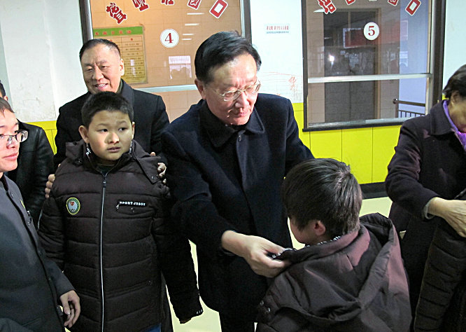 中华慈善总会会长李本公（居中）为吕梁市残疾人职业技能学校贫困残疾孩子穿上棉衣.jpg