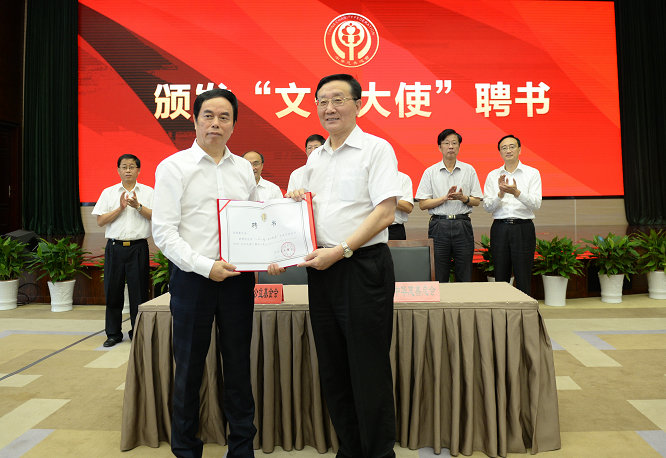 中华慈善总会会长李本公向波司登公益基金创始人高德康颁发“一带一路 民心相通”学生手拉手活动“文化大使”聘书。.JPG